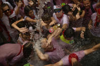 <p>Revelers cool down as water is thrown from balconies after the launch of the <em>chupinazo</em> rocket to celebrate the official opening of the 2017 San Fermín Fiesta. (Photo: Alvaro Barrientos/AP) </p>