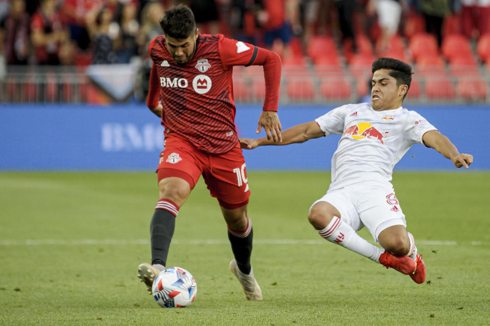 Toronto FC midfielder Alejandro Pozuelo (10) is defended by New York Red Bulls midfielder Frankie Amaya (8) during the first half of an MLS soccer match Wednesday, July 21, 2021, in Toronto. (Chris Katsarov/The Canadian Press via AP)