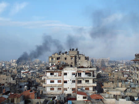 FILE PHOTO: Smoke rises from one of the buildings in the city of Homs, Syria March 11, 2013. REUTERS/Yazan Homsy/File Photo