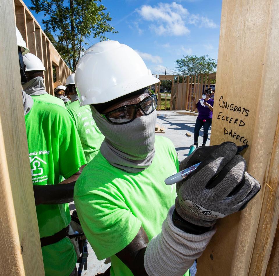 In this 2020 file photo, Darrell Wilkerson with CareerSource Citrus Levy Marion and the Phoenix Rising YouthBuild program writes a message on one of the studs used in a wall at a home in Silver Spring Shores.