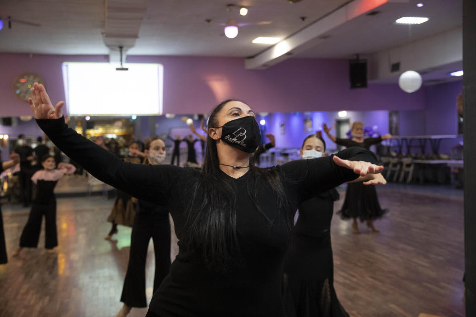 New dancing Days owner Raffaella Serafini gives directions to dancers during a practice in Rome, Wednesday, March 24, 2021. While much of Italy is in coronavirus lockdown, with live music and theatrical performances barred, cinemas shuttered and many sporting activities limited, competitive ballroom dancing is alive and well here, albeit with precautions. (AP Photo/Alessandra Tarantino)