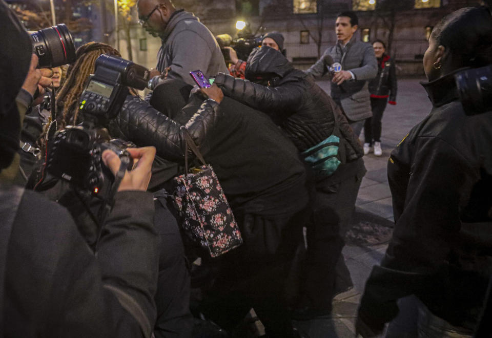 Supporters surround and hide from view one of two jail guards, center, responsible for monitoring Jeffrey Epstein the night he killed himself, following their federal court arraignment charge for falsifying prison records, Tuesday Nov. 19, 2019, in New York. (AP Photo/Bebeto Matthews)