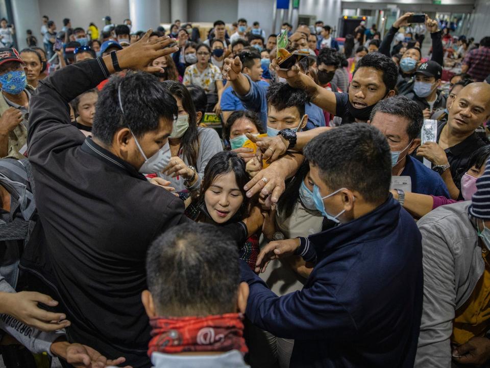 Airport security staff attempt to control the crowd as Filipinos hoping to get on flights out of Manila hours before it is placed on lockdown queue at Ninoy Aquino International Airport on March 14, 2020 in Manila, Philippines.