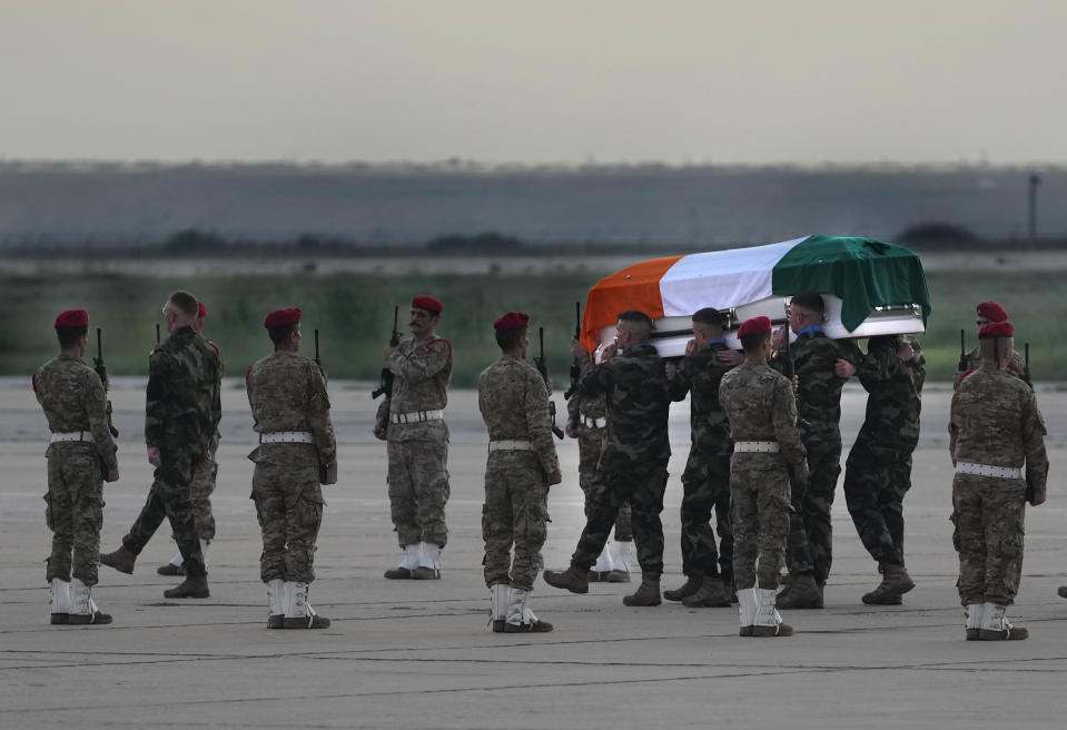 Irish U.N peacekeepers carry the coffin draped by their country flag of their comrade Pvt. Seán Rooney who was killed during a confrontation with residents near the southern town of Al-Aqbiya on Wednesday night, during his memorial procession at the Lebanese army airbase, at Beirut airport, Sunday, Dec. 18, 2022. (AP Photo/Hussein Malla)