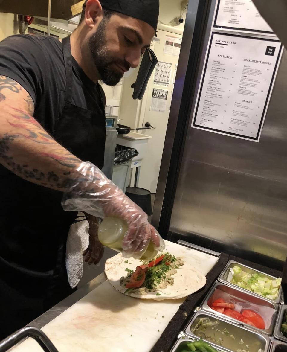Chef Elias Haddad, owner of The Rock Yard restaurant and pub, makes a baba ghanoush pita sandwich.
