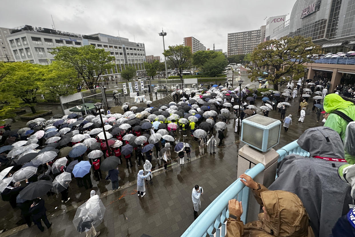 People wait for one of candidate's stump speech as Japan's Prime Minister and President of the ruling Liberal Democratic Party Fumio Kishida attending during an election campaign for the upcoming unified local elections Saturday, April 15, 2023, in Urayasu, near Tokyo. (AP Photo/Richard Colombo)