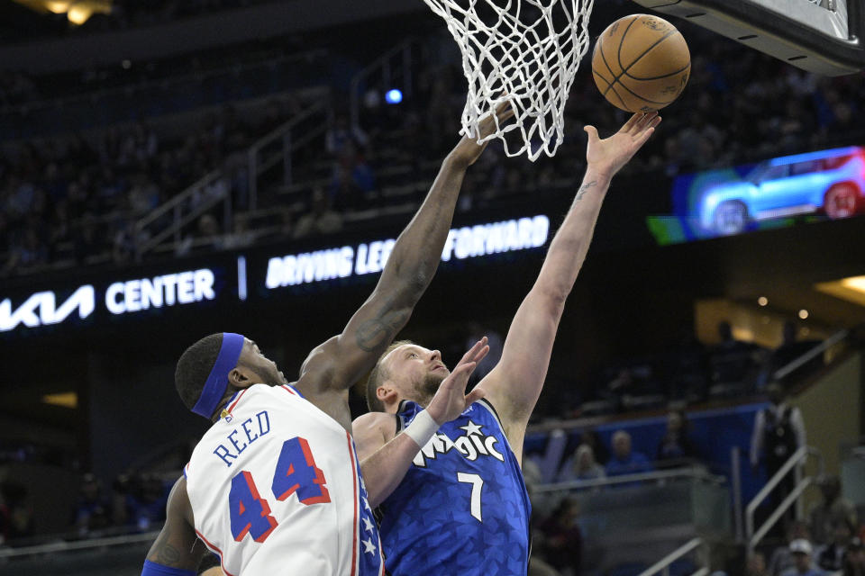 Orlando Magic guard Joe Ingles (7) shoots next to Philadelphia 76ers forward Paul Reed (44) during the first half of an NBA basketball game Friday, Jan. 19, 2024, in Orlando, Fla. (AP Photo/Phelan M. Ebenhack)