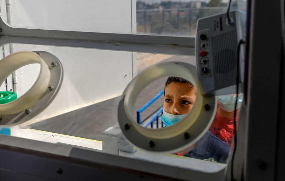 Image: A Palestinian child prepares to get checked for coronavirus at a mobile testing station in Sheikh Jarrah, Jerusalem on Monday. (Ahmad Gharabli / AFP - Getty Images)