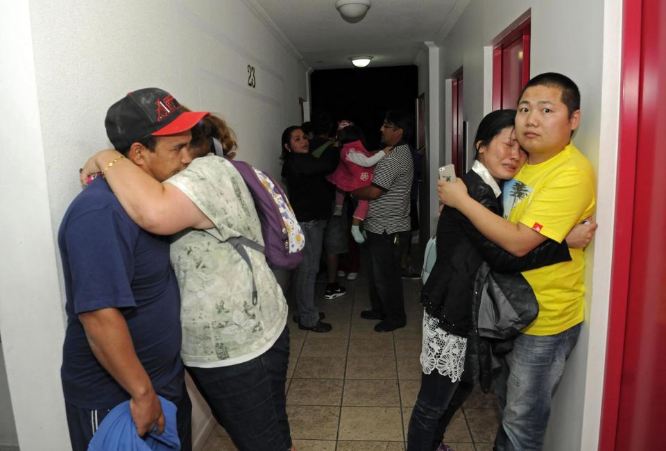 Varias personas se abrazan en el último piso de un edificio de apartamentos a pocas cuadras de distancia de la costa, donde se reunieron para evitar las consecuencias de un posible tsunami tras el fuerte terremoto en Iquique, Chile, el martes 1 de abril de 2014. Un poderoso sismo de mangitud 8,2 sacudió la costa norte de Chile al martes por la noche. No hubo reportes inmediatos de lesionados o grandes daños, pero los edificios temblaron en Perú y en La Paz, capital de Bolivia. (Foto AP/Cristian Viveros) NO PUBLICAR EN CHILE