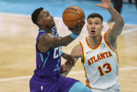 Charlotte Hornets guard Terry Rozier, left, drives to the basket against Atlanta Hawks guard Bogdan Bogdanovic, right, during the third quarter of an NBA basketball game in Charlotte, N.C., Sunday, April 11, 2021. (AP Photo/Nell Redmond)