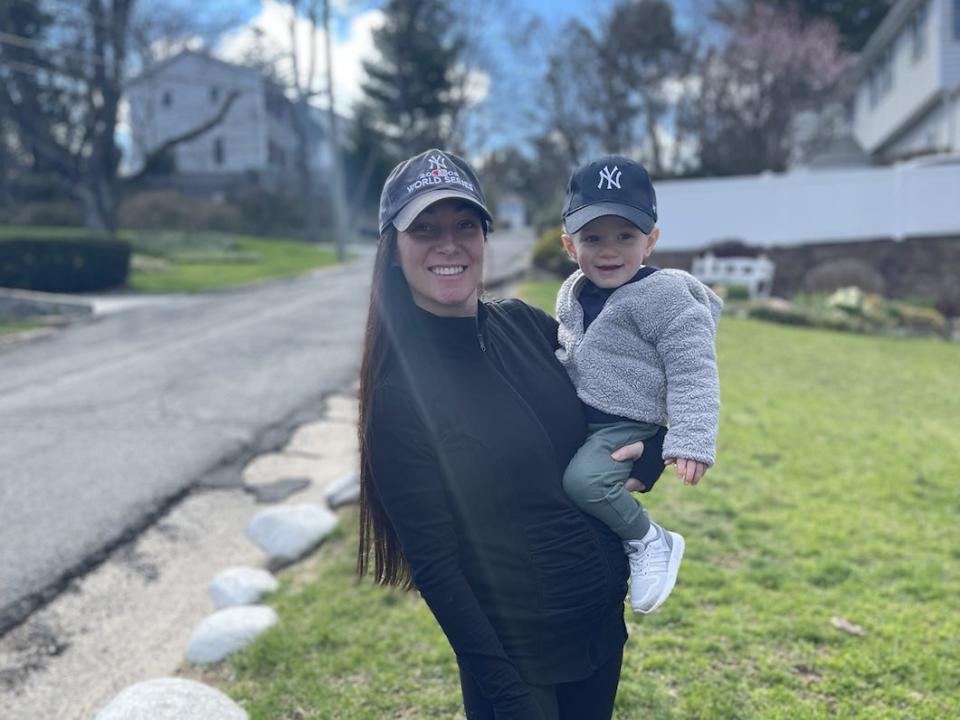 Jackie Cucullo, then seven months' pregnant with her second child, poses with her son, JP, on a street.