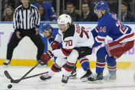 New Jersey Devils center Jesper Boqvist (70) battles for the puck against New York Rangers right wing Kaapo Kakko (24) in the third period of an NHL hockey game, Monday, Nov. 28, 2022, in New York. (AP Photo/John Minchillo)