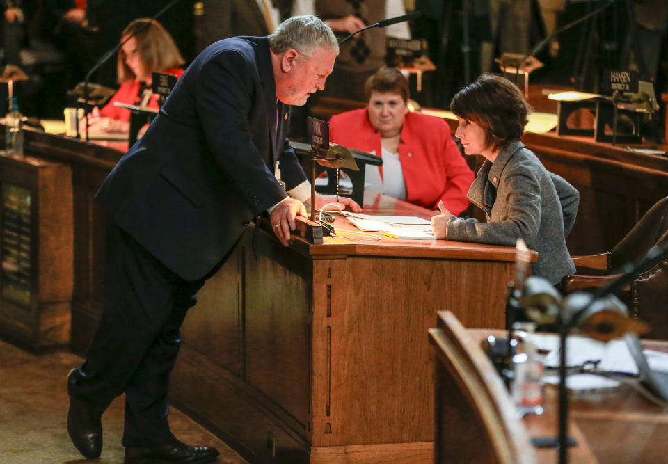 FILE - Clerk of the Legislature Patrick O'Donnell, left, speaks with State Sen. Nicole Fox, of Omaha, in the Legislative Chamber on the opening day of the legislature in Lincoln, Neb., on Jan. 6, 2016. O'Donnell, who served for 45 years as the clerk of the Legislature before retiring in December 2022, says partisanship has tainted the officially nonpartisan, one-house Nebraska Legislature. He called the latest session that ended Thursday, June 1, 2023, "the worst we've had." (AP Photo/Nati Harnik, File)