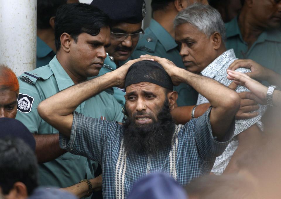 A prisoner reacts as police force him into a van after the verdict for a 2009 mutiny is announced, in Dhaka