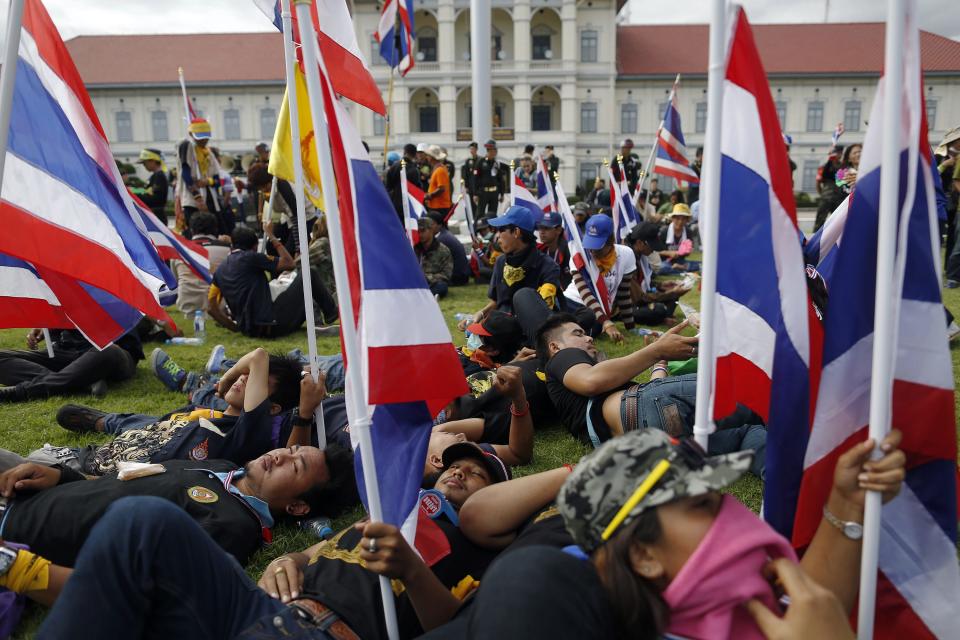 Anti-government protesters rest after breaking into the compound of the Royal Thai Army headquarters in Bangkok