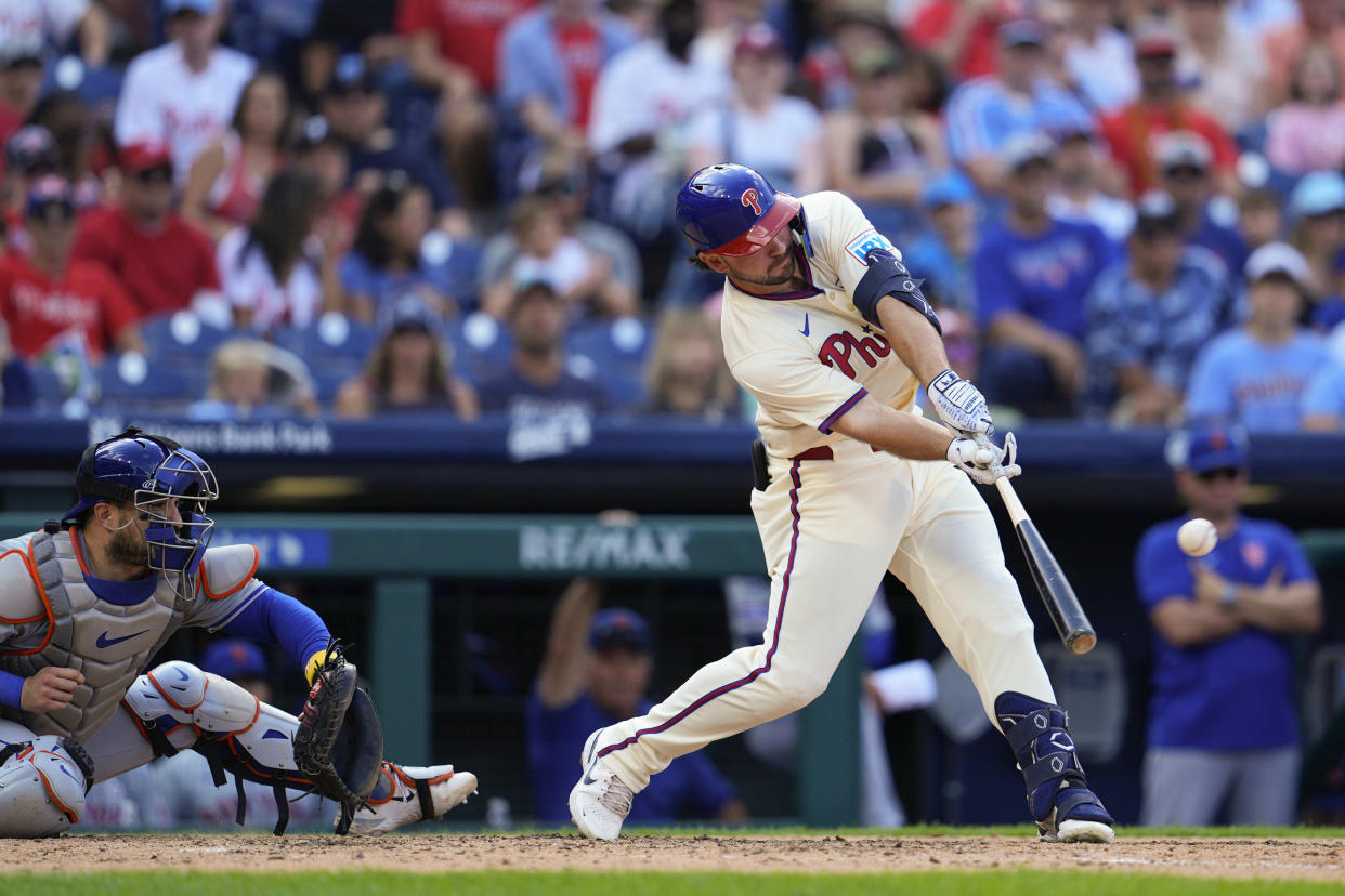 Philadelphia Phillies' Buddy Kennedy, right, hits an RBI double off New York Mets' David Peterson during the eighth inning of a baseball game, Sunday, Sept. 15, 2024, in Philadelphia. (AP Photo/Derik Hamilton)