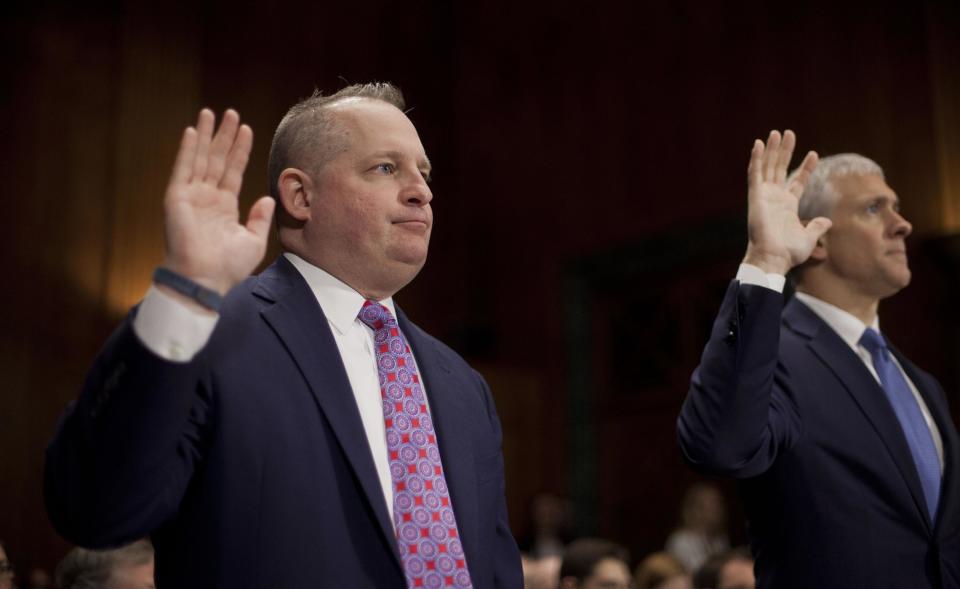 John J. Mulligan, executive Vice President and Chief Financial Office of Target Corporation, left, and Michael R. Kingston, senior Vice President and Chief Information Officer of the Neiman Marcus Group, are sworn-in on Capitol Hill in Washington, Tuesday, Feb. 4, 2014, prior to testifying before the Senate Judiciary Committee hearing on data breaches and combating cybercrime. (AP Photo/Pablo Martinez Monsivais)