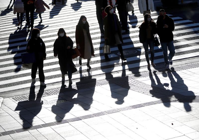 Year-end shoppers wearing protective face masks are seen at a shopping and amusement district, amid the coronavirus disease (COVID-19) outbreak, in Tokyo