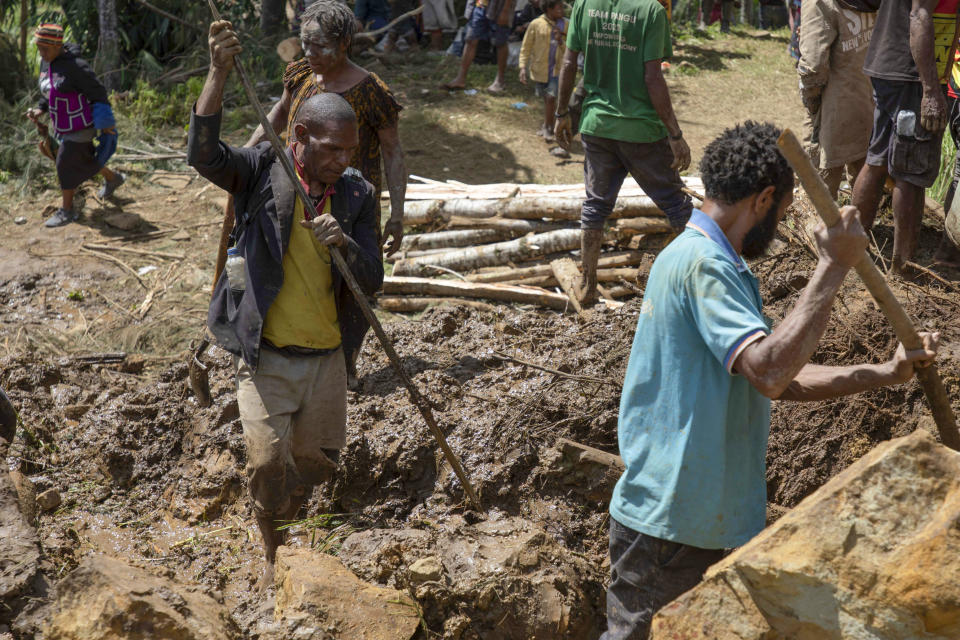 In this photo released by UNDP Papua New Guinea, villagers search through a landslide in Yambali village, in the Highlands of Papua New Guinea, Monday, May 27, 2024. Authorities fear a second landslide and a disease outbreak are looming at the scene of Papua New Guinea's recent mass-casualty disaster because of water streams trapped beneath tons of debris and decaying corpses seeping downhill following the May 24 landslide. (Juho Valta/UNDP Papua New Guinea via AP)