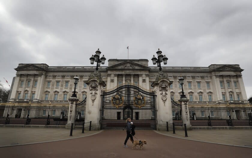 ARCHIVO – Una mujer camina con un perro y un bebé frente al Palacio de Buckingham el 23 de marzo de 2021. El gasto del presupuesto público de la monarquía británica aumentó 17% a 102,4 millones de libras esterlinas (124 millones de dólares) en el último año, de los cuales la renovación del Palacio de Buckingham requirió una gran cantidad, según un reporte publicado el jueves 30 de junio de 2022. (Foto AP/Kirsty Wigglesworth, archivo)