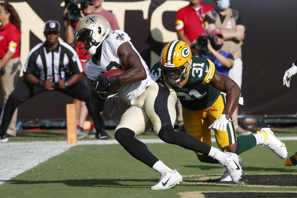 New Orleans Saints tight end Juwan Johnson, left, makes a touchdown reception in front of Green Bay Packers strong safety Adrian Amos (31) during the first half of an NFL football game, Sunday, Sept. 12, 2021, in Jacksonville, Fla. (AP Photo/Stephen B. Morton)