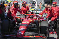 Mechanics push Ferrari driver Carlos Sainz of Spain back into their pit lane garage during the first practice session of the Australian Formula One Grand Prix at Albert Park, in Melbourne, Australia, Friday, March 22, 2024. (AP Photo/Asanka Brendon Ratnayake)