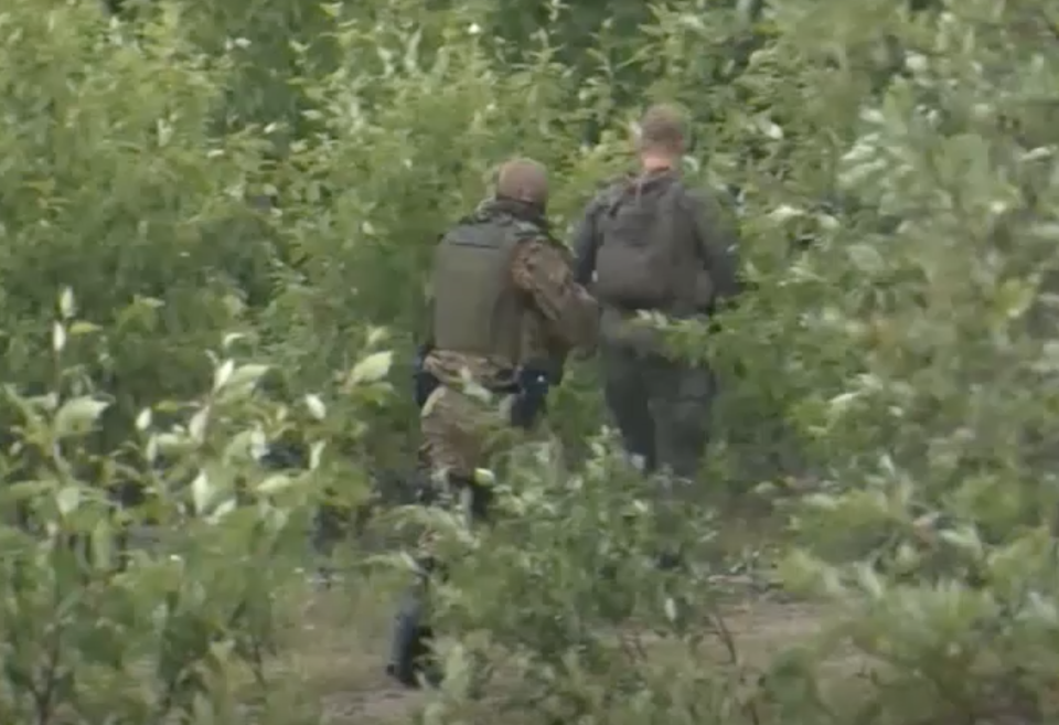 Photos show police searching dense bushland for Bryer Schmegelsky and his co-accused Kam McLeod.