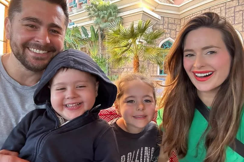 Photo of dad Jamie, Billy, Maddie and Ellie on holiday with a hotel background