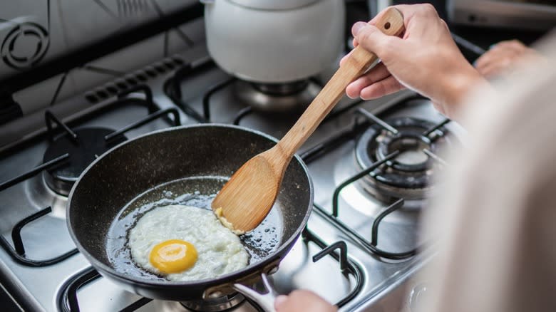 Woman frying an egg