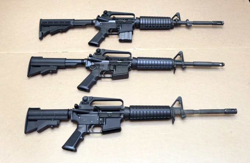 FILE - In this Aug. 15, 2012 file photo, three variations of the AR-15 rifle are displayed at the California Department of Justice in Sacramento, Calif. On Sept. 19, 2019, Connecticut-based Colt Firearms said it was suspending production of its version of the AR-15 for the civilian market. (AP Photo/Rich Pedroncelli, File)