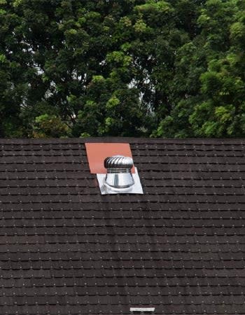 A single attic fan is seen on a roof.