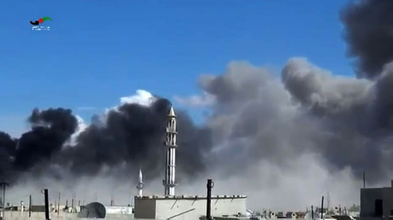 Smoke billows from buildings and a minaret in the central Syrian town of Talbisseh in Homs province, in a video image released by the Homs Media Center on September 30, 2015