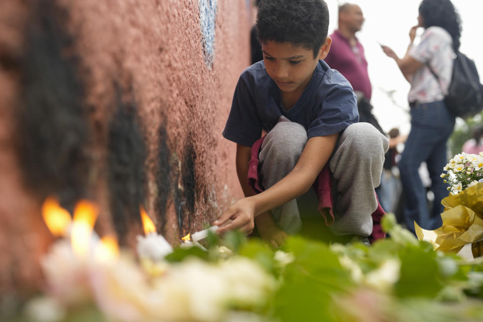 FILE - A student from the Thomazia Montoro public school lights a candle during a vigil asking for peace the day after a student stabbed a teacher to death at the school in Sao Paulo, Brazil, March 28, 2023. Brazil is grappling with a wave of violence in its schools. The government has sought input from independent researchers and convened a meeting on Tuesday, April 18, 2023, of ministers, mayors and Supreme Court justices to discuss possible solutions. (AP Photo/Andre Penner, File)