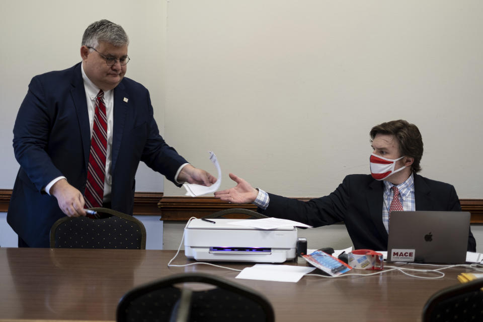 FILE - Then-Georgia Republican Party Chairman David Shafer, left, hands a document to Robert Sinners, a staffer for Donald Trump’s 2020 reelection campaign, during a meeting of Republican electors who cast votes for Trump and Vice President Mike Pence at the Georgia Capitol, Dec. 14, 2020, in Atlanta. The meeting of the electors has become a key element in the prosecution of Trump and 18 others in Georgia. Smith is one of the four people present that day who was indicted by a Fulton County grand jury in August 2023 on charges that he conspired to illegally overturn Democrat Joe Biden's win in Georgia. (AP Photo/Ben Gray, File)