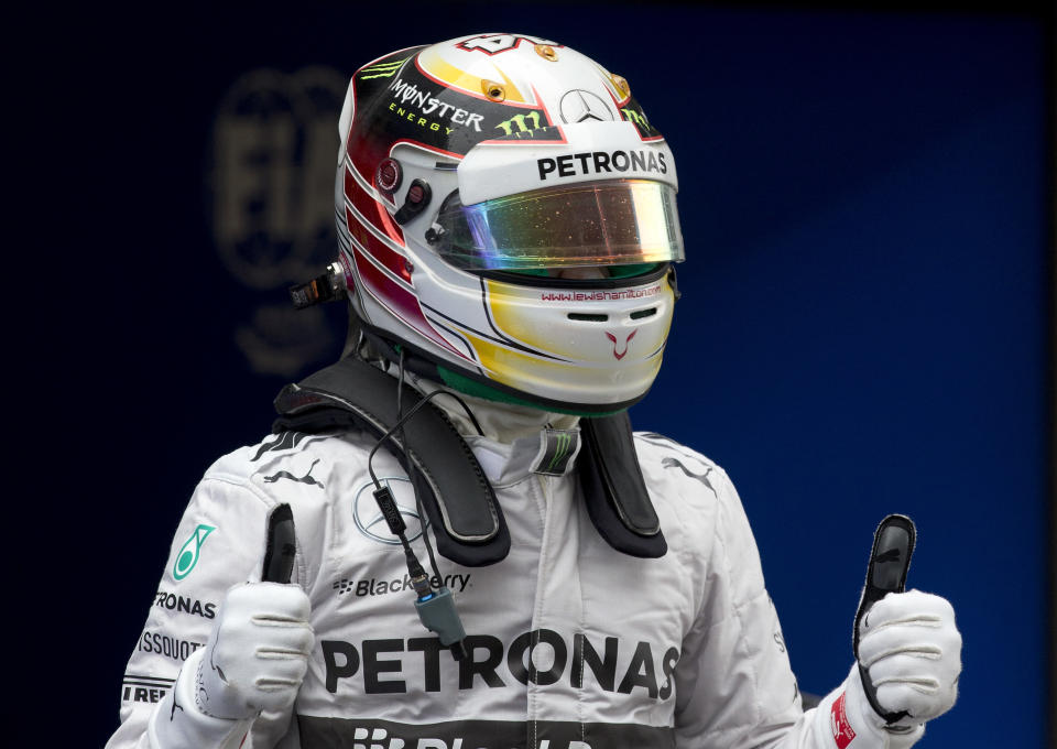 Mercedes driver Lewis Hamilton of Britain celebrates after he won the pole position for Sunday's Chinese Formula One Grand Prix at Shanghai International Circuit in Shanghai, China Saturday, April 19, 2014. (AP Photo/Andy Wong)