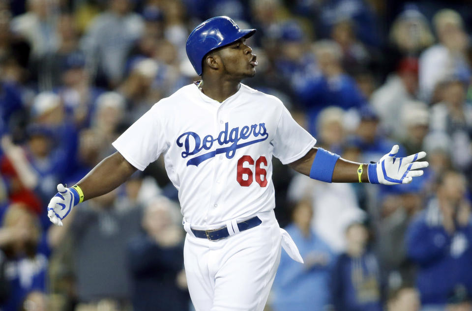 Los Angeles Dodgers' Yasiel Puig exchanges words with San Francisco Giants starting pitcher Madison Bumgarner as Puig runs down the third base line after hitting a solo home run during the sixth inning of a baseball game, Friday, May 9, 2014, in Los Angeles. (AP Photo/Danny Moloshok)