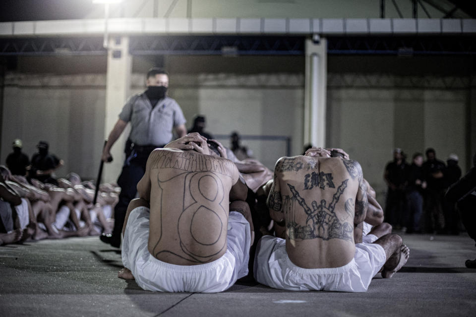 Un guardia de prisión vigila a los pandilleros mientras son procesados ​​a su llegada al <strong>Centro del Confinamiento del Terrorismo (Cecot)</strong>, como parte de una medida anunciada por el presidente de El Salvador, Bukele, en las redes sociales, en Tecoluca, El Salvador, el 11 de junio de 2024. Secretaria de Prensa de la Presidencia/Folleto vía REUTERS