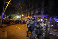 Policemen in riot gear charge against protestors outside the Spanish Government Office in Barcelona, Spain, Tuesday, Oct. 15, 2019. Spain's Supreme Court on Monday convicted 12 former Catalan politicians and activists for their roles in a secession bid in 2017, a ruling that immediately inflamed independence supporters in the wealthy northeastern region. (AP Photo/Emilio Morenatti)