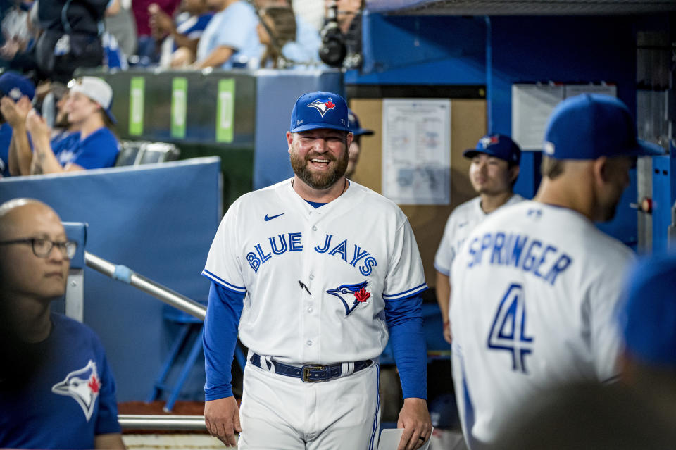 Interim manager John Schneider, center, speaks with teammates before a baseball game against the Philadelphia Phillies Wednesday, July 13, 2022 in Toronto. (Christopher Katsarov/The Canadian Press via AP)