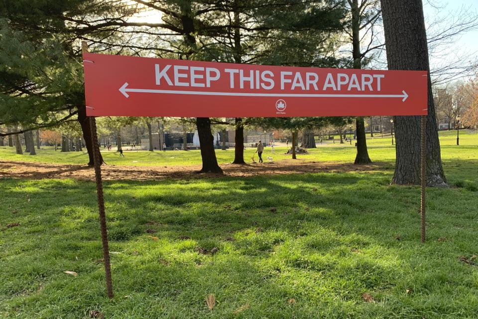 Signage urging social distancing is seen in Prospect Park in the Brooklyn borough of New York, Wednesday, April 8, 2020. While New York Gov. Andrew Cuomo said New York could be reaching a "plateau" in hospitalizations, he warned that gains are dependent on people continuing to practice social distancing. (AP Photo/Wong Maye-E)