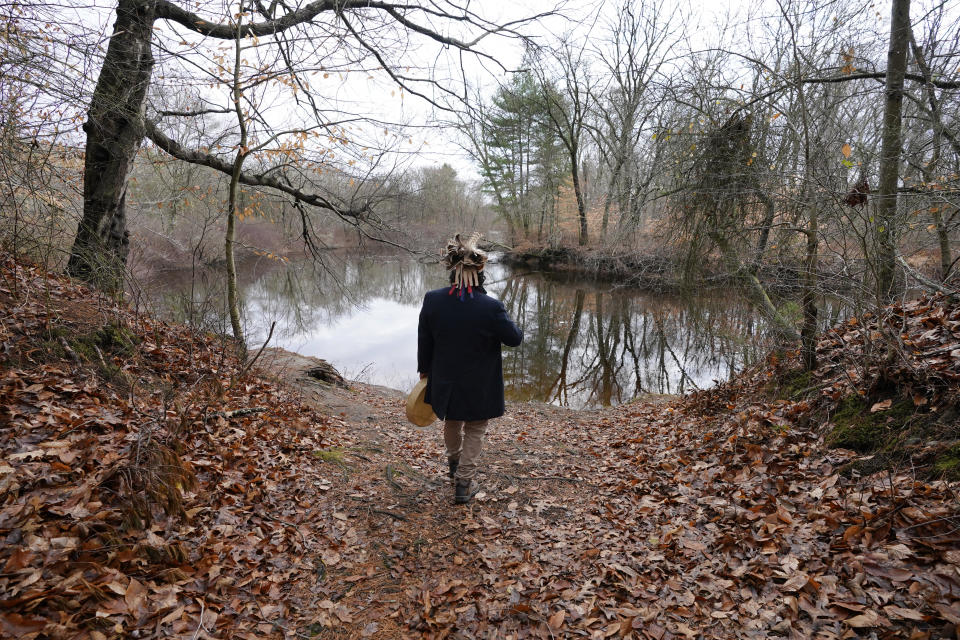 Larry Fisher, chief sachem of the Mattakeeset Massachuset tribe, walks with his drum to the Taunton River at Titicut Indian Reservation, Friday, Nov. 27, 2020, in Bridgewater, Mass. A rift has been widening between Native American groups in New England over a federal reservation south of Boston where one tribe is planning to build a $1 billion casino. The Mattakeeset Massachuset tribe contend the Mashpee Wampanoag tribe doesn't have exclusive claim to the lands under their planned First Light casino in the city of Taunton, as they've argued for years. (AP Photo/Elise Amendola)