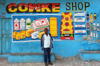 <p>Artist Muawiye Hussein Sidow, also known as Shik Shik, stands in front of a mural he painted on a shop wall in Mogadishu, Somali, July 21, 2017. (Photo: Feisal Omar/Reuters) </p>