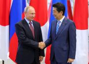 Japanese Prime Minister Shinzo Abe, right, and Russian President Vladimir Putin shake hands prior to their talks at the Eastern Economic Forum in Vladivostok, Russia, Monday, Sept. 10, 2018. (Mikhail Klimentyev, Sputnik, Kremlin Pool Photo via AP)