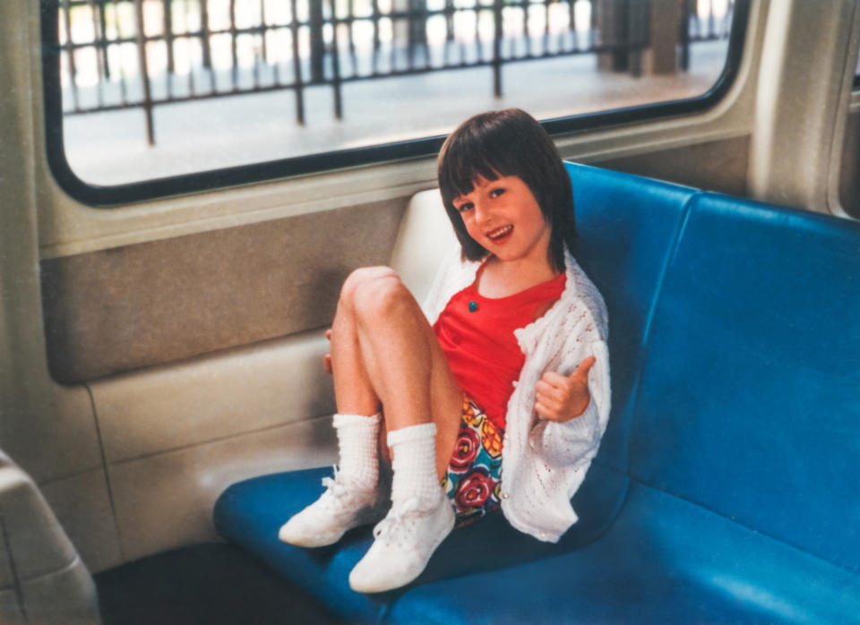 A little girl is seated in a bus