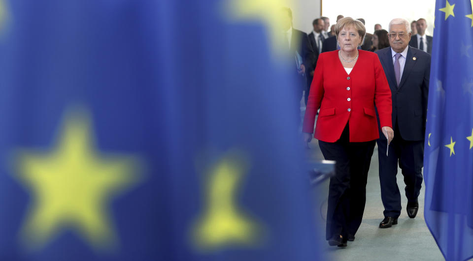 German Chancellor Angela Merkel, left, and Palestinian President Mahmoud Abbas, right, arrive for a joint statement prior to a meeting at the Chancellery in Berlin, Germany, Thursday, Aug. 29, 2019. (AP Photo/Michael Sohn)