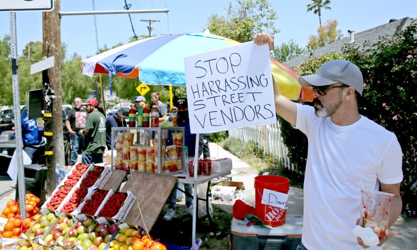 Kelly Parra, 50 of Woodland Hills, shows his support for street fruit vendor Tomas Escamilla at the corner of Canoga Ave. and Dumetz Road, in Woodland Hills on Saturday, May 7, 2022. A rally was held today in support of Escamilla after he was recently attacked by a local neighbor who destroyed his fruit cart.