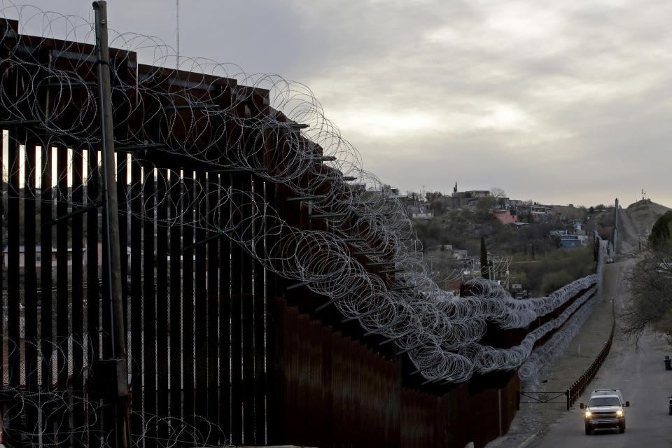 A U.S. Customs and Border Protection agent patrols on the U.S. side of a razor-wire-covered border barrier that separates Nogales, Mexico, from Nogales, Arizona. (Photo: Charlie Riedel/ASSOCIATED PRESS)