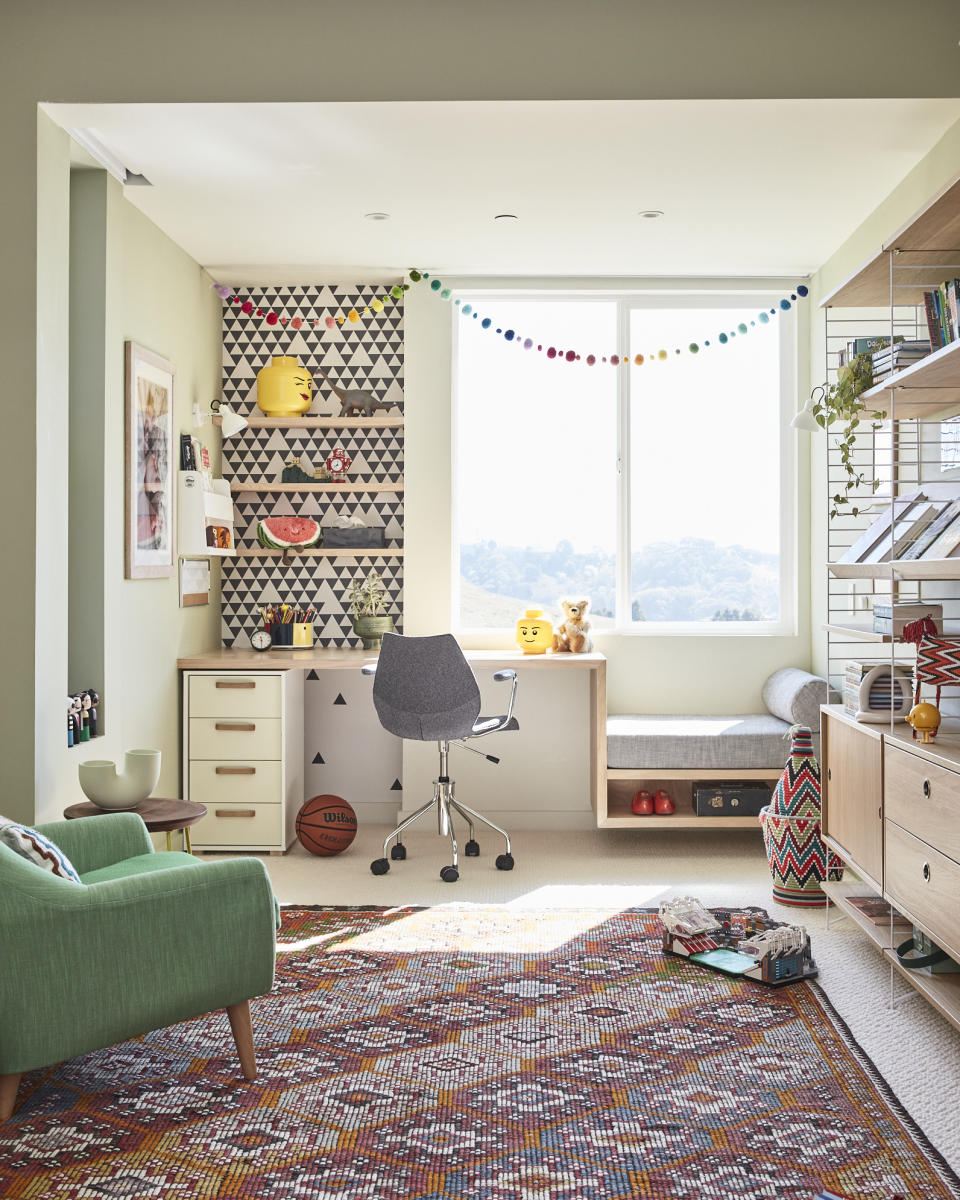 teen kids/bedroom ideas with wallpaper, desk, multicolored rug, green armchair, storage units