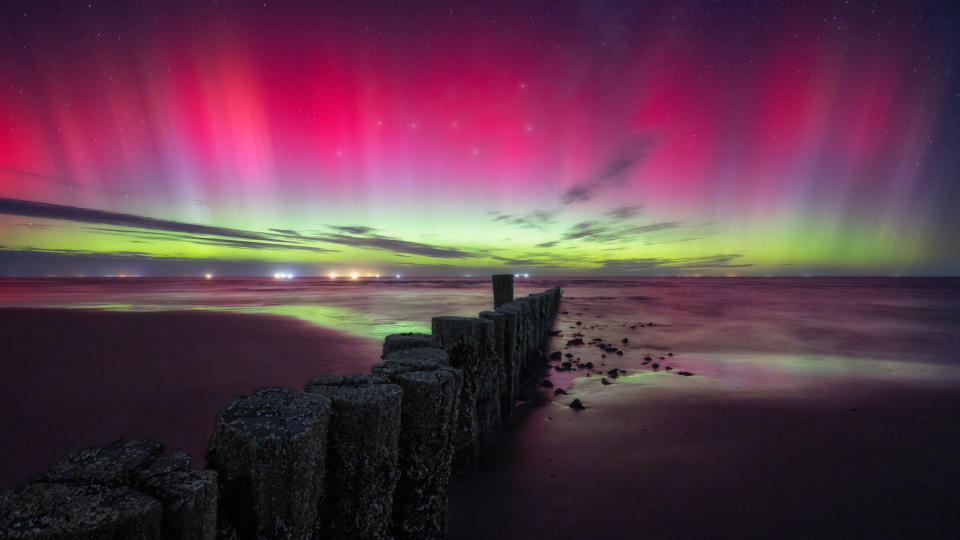 Magenta and green northern lights over Wadden Sea National Parks, Germany.