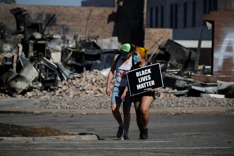 Protesters wearing face masks walk with a Black Life Matters sign in Minneapolis